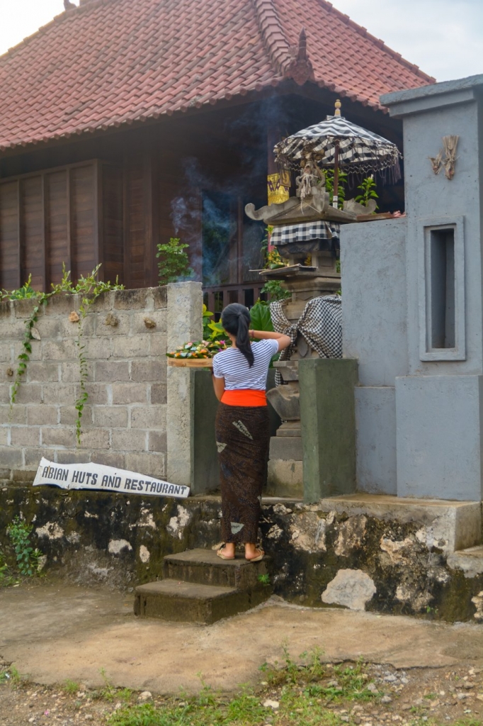 Kobieta składa ofiarę na ołtarzyku znajdującym się koło Abian Huts